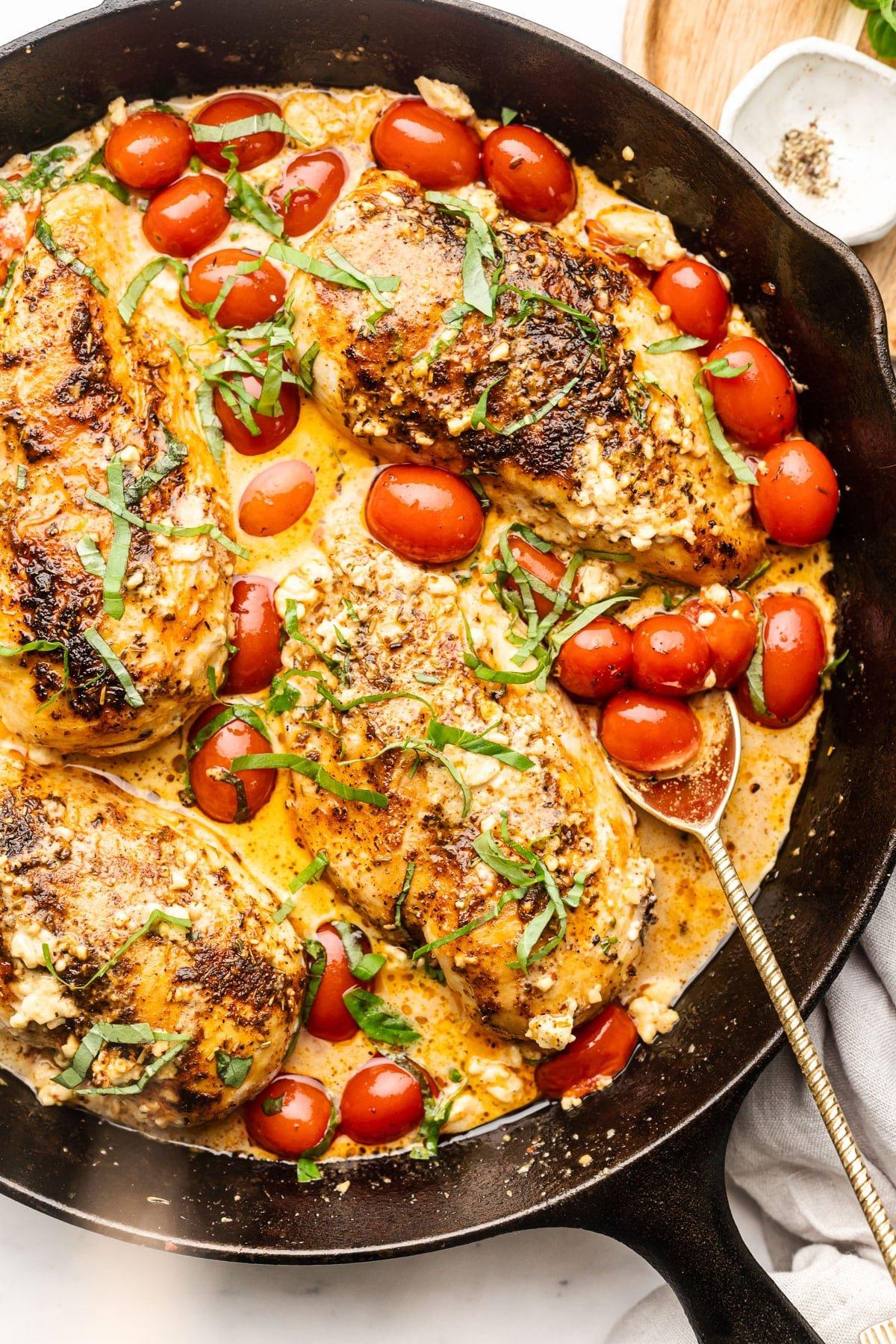 Gebackenes Feta-Hähnchen mit Tomaten und Knoblauch in einer gusseisernen Pfanne
