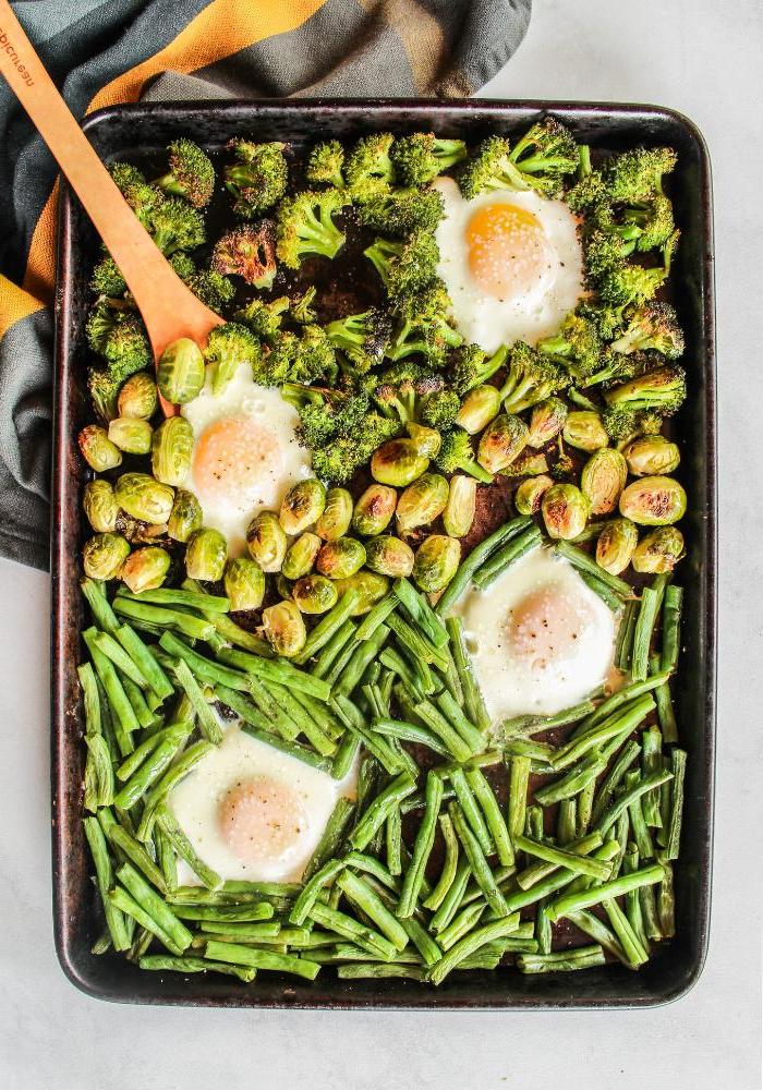 Vegetarische Frühstücks-Bowls vom Backblech 2 Geröstetes Gemüse und Spiegeleier auf einem Blech für gesunde Frühstücks-Bowls, bereit zum Servieren