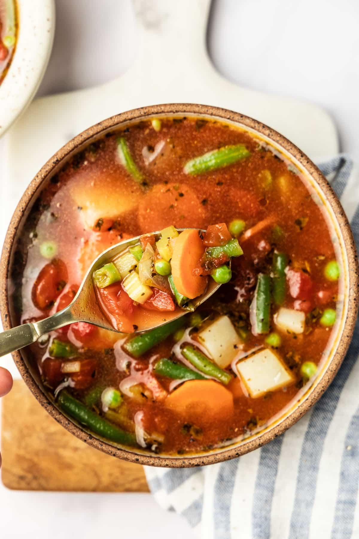 30-Minuten-Gemüsesuppe 2 Frisch zubereitete herzhafte Gemüsesuppe in einer rustikalen Schüssel, dampfend und bereit zum Servieren.