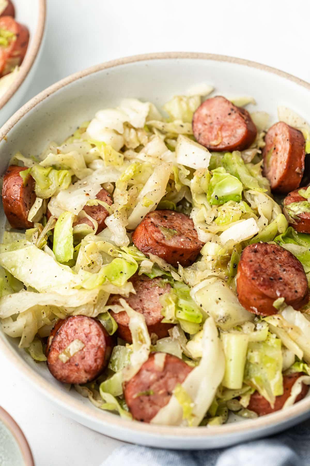 Einfache Wurst-Kohl-Pfanne 2 Deftiges Low-Carb Wurst-Kohl-Pfannengericht in einer Pfanne angerichtet