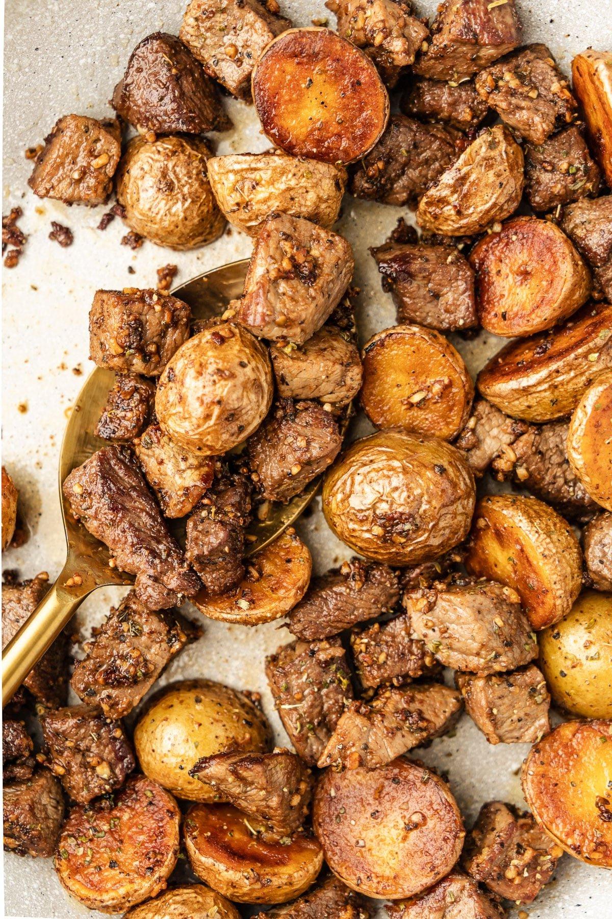 Knoblauch-Steak und Kartoffeln 2 Saftiges Steak und goldbraune Kartoffeln in einer Pfanne, bereit zum Servieren.