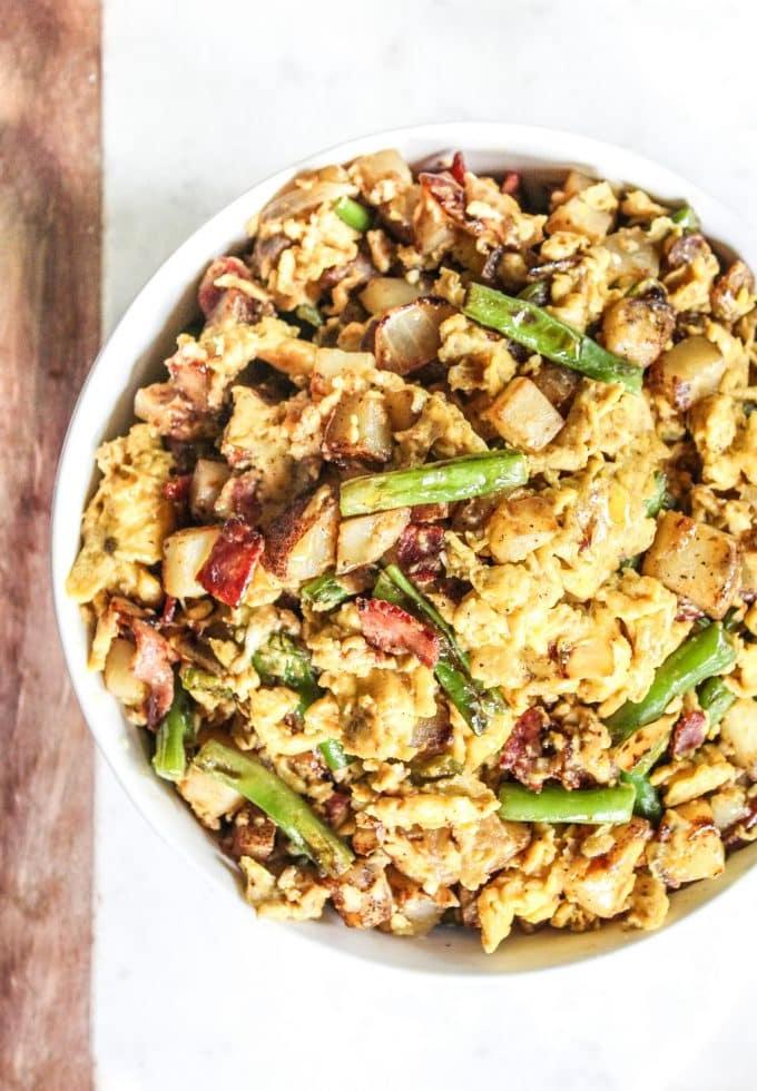 Wochenendfrühstückspfanne 2 Ein reichhaltiges Rührei mit Speck, Kartoffeln und grünen Bohnen in einer gusseisernen Pfanne, bereit zum Servieren.