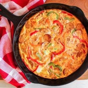 Frittata mit Hähnchenwurst und Paprika 2 Farbenfrohe Hühnerwurst-Paprika-Frittata in einer Gusseisenpfanne