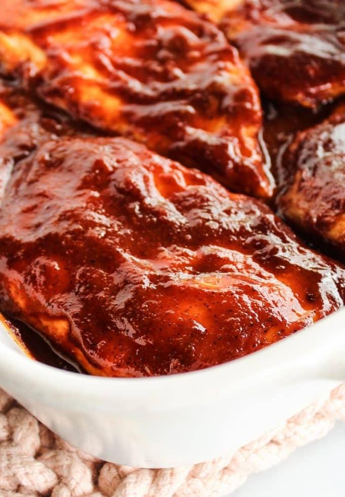 Ofengebackenes Barbecue-Hähnchen 2 Saftiges Ofen-BBQ-Hähnchen, reichlich mit hausgemachter Barbecue-Sauce überzogen, auf einem Backblech angerichtet.