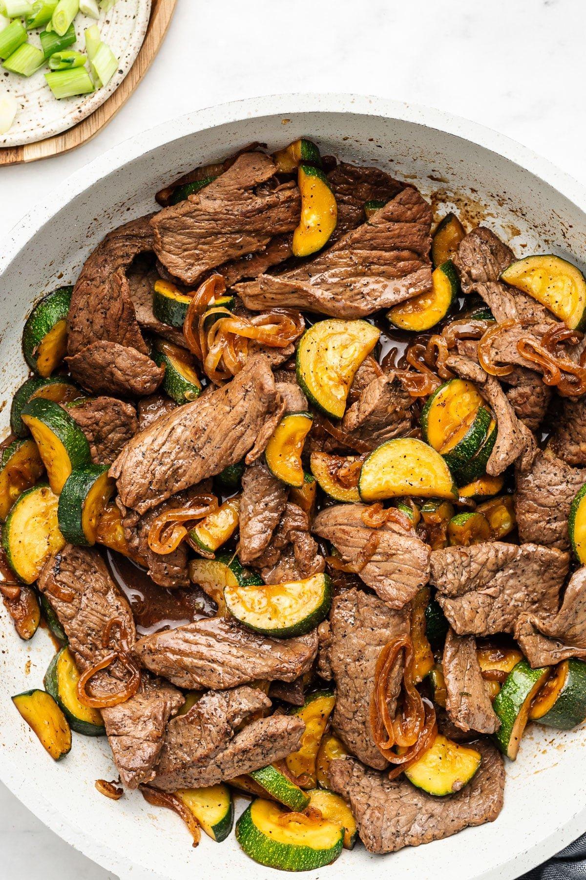 Steak-Zucchini-Pfanne 2 Fertiges Rindfleisch-Zucchini-Pfannengericht in einer Pfanne, bereit zum Servieren.