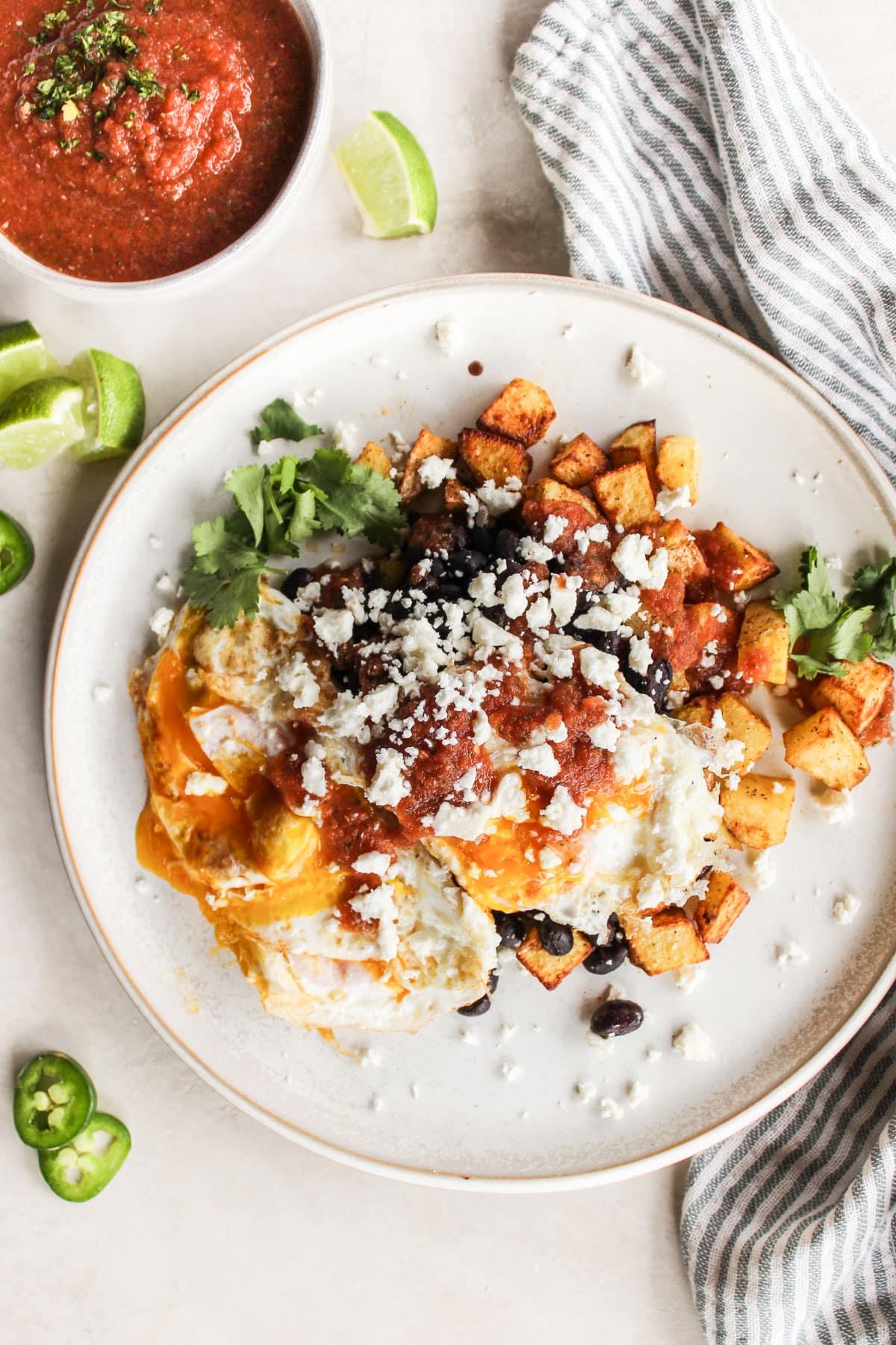 Kartoffel-Huevos Rancheros 2 Fertig angerichtete Kartoffel-Huevos Rancheros auf einem Teller, von oben fotografiert.