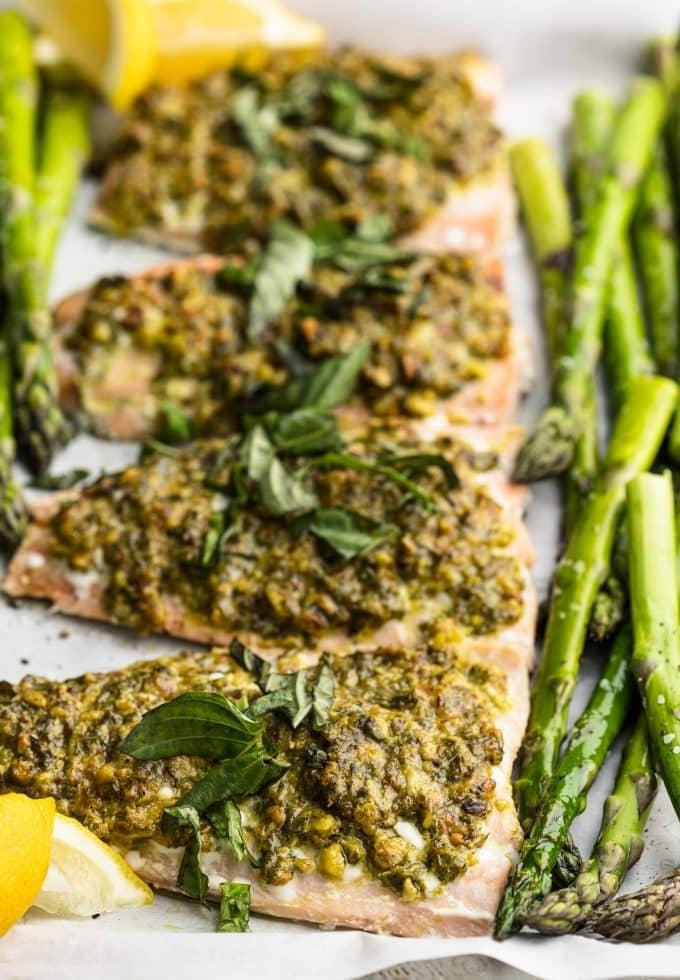 Lachs in Pistazien-Kräuter-Kruste mit Spargel 2 Frisch gebackener Lachs mit Pistazien-Kräuter-Kruste und Spargel auf einem Backblech, bereit zum Servieren