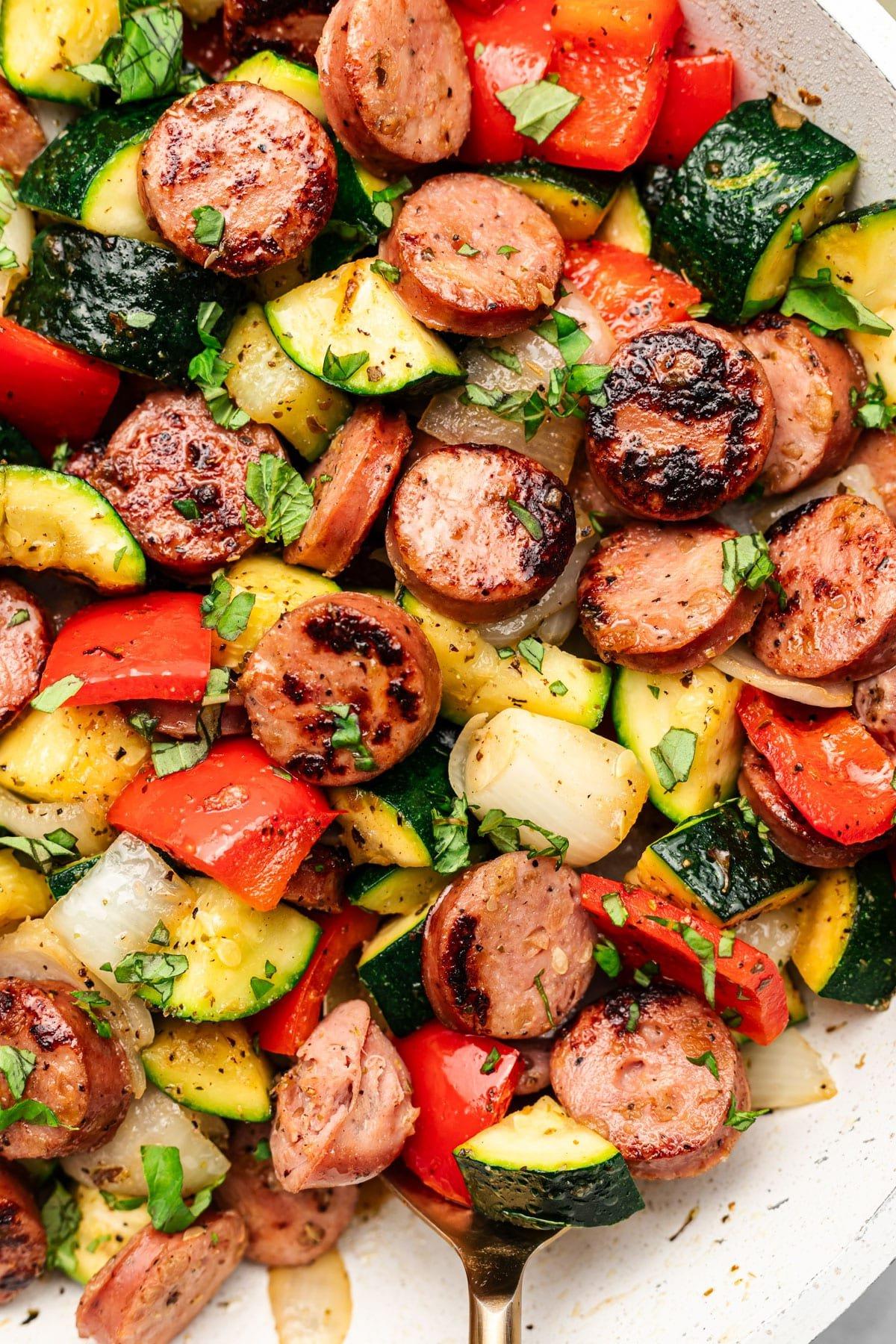 **20-Minuten-Wurst-Zucchini-Pfanne** 2 Frisch zubereitete Zucchini-Wurst-Pfanne, angerichtet und bereit zum Servieren.