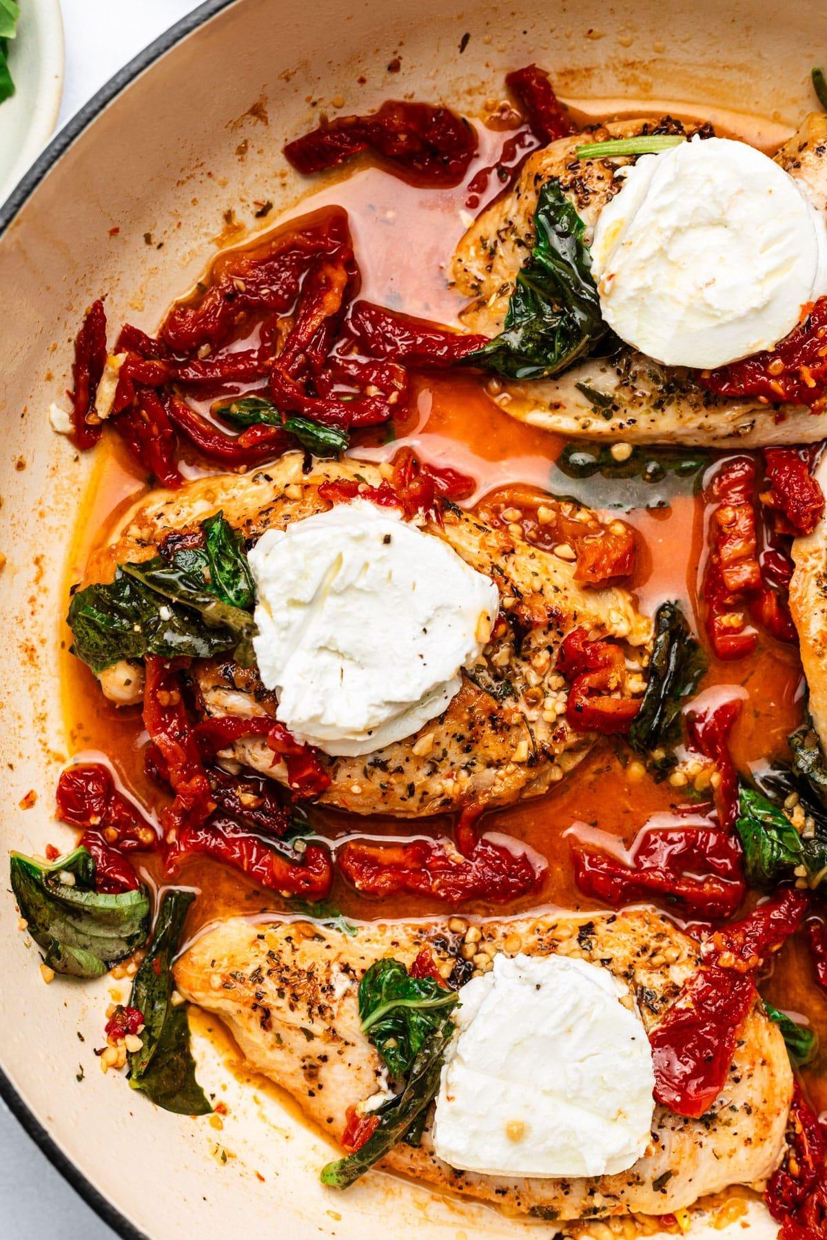 Sonnengetrocknete Tomaten-Ziegenkäse-Hähnchen (nach Art von Chicken Bryan) 2 Saftiges Hähnchen mit Ziegenkäse, getrockneten Tomaten und Basilikum auf einem Teller.