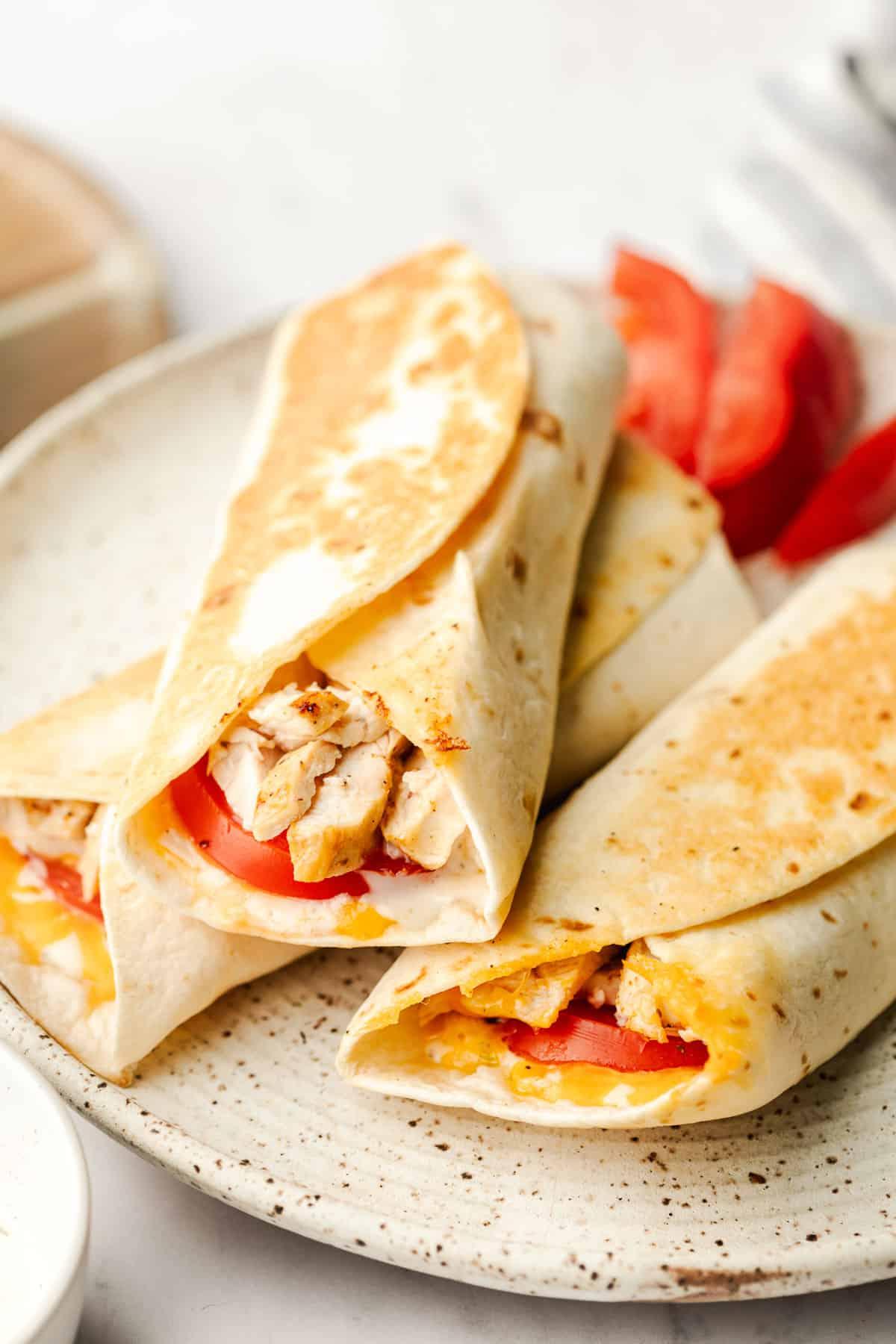 Gegrillte Ranch-Hähnchen-Wraps 2 Frisch zubereitete Hähnchen-Ranch-Wraps auf einem Schneidebrett, bereit zum Servieren.