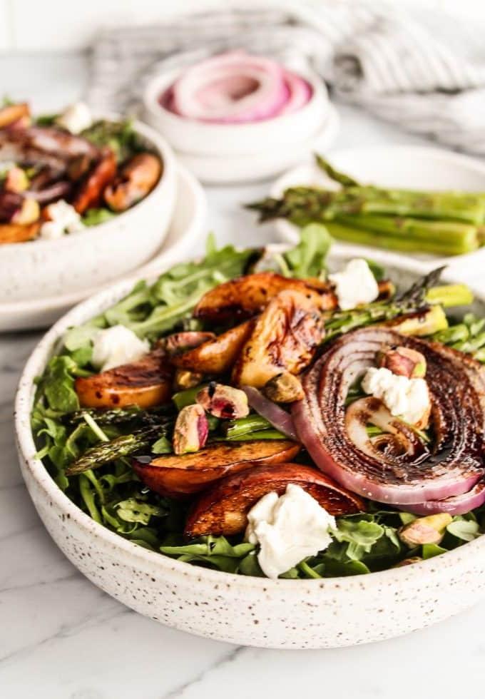 Gerösteter Pfirsich-Rucola-Salat mit Balsamico-Reduktion in einer rustikalen Schüssel, bereit zum Servieren