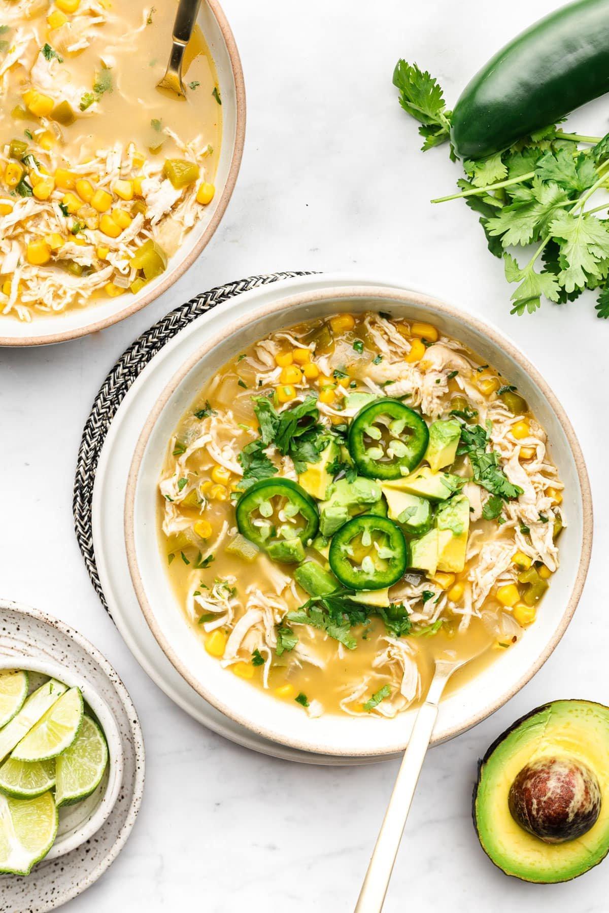 Salsa Verde Hühnersuppe in einer Schale mit frischen Garnierungen.