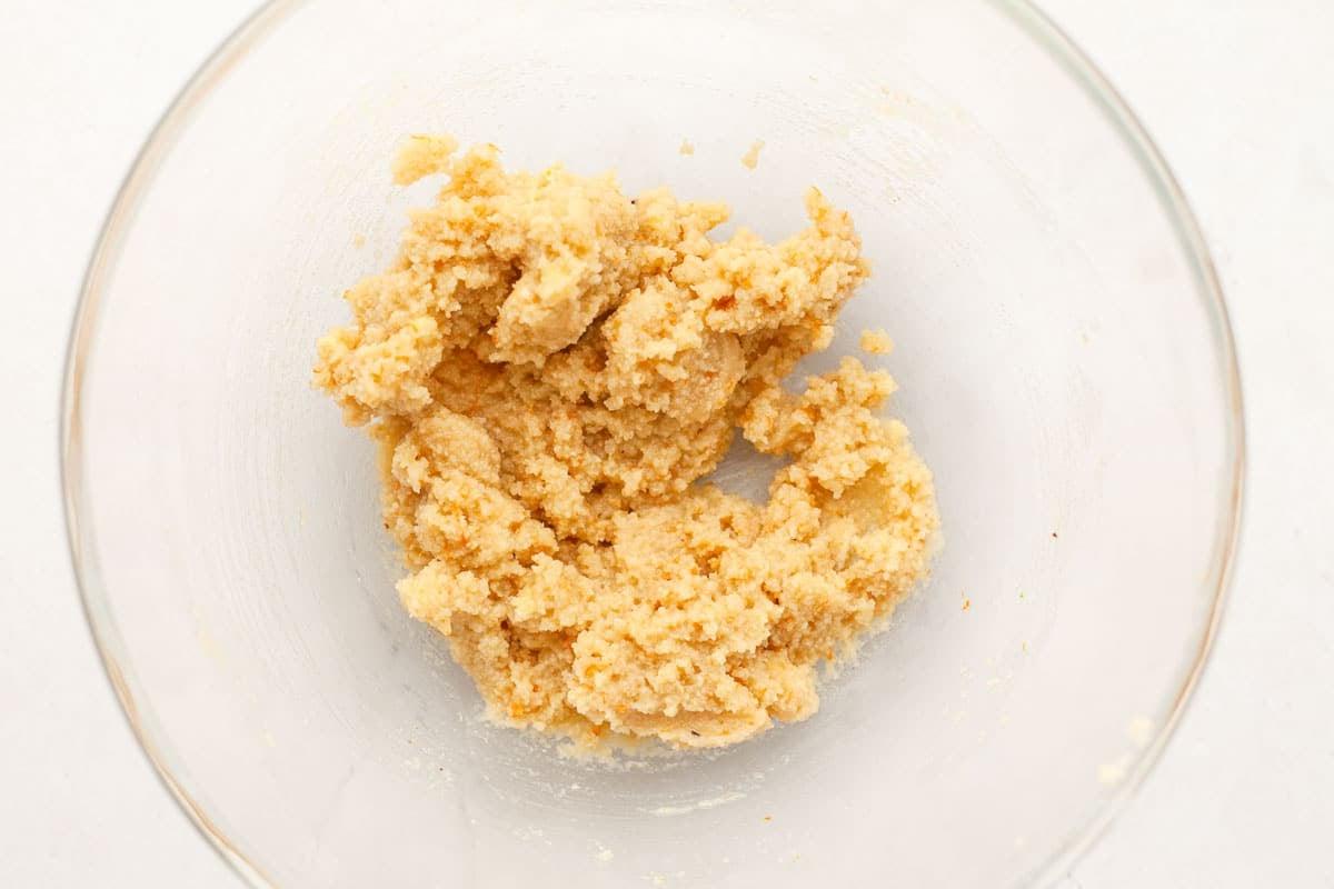 Orangen-Zutaten: Orangenschale und Orangensaft in Schalen, daneben eine frische Orange.