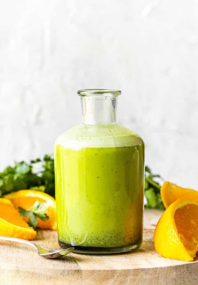 Zutaten für Koriander-Zitrus-Vinaigrette auf einer Küchenzeile, darunter Koriander, Orangen, Limetten, Olivenöl und Essig