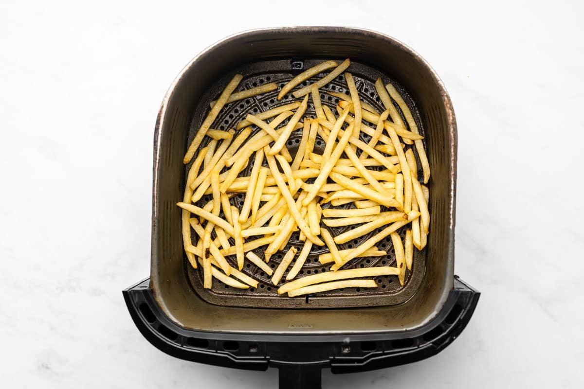 Tiefkühl-Pommes aus der Heißluftfritteuse 3 Fertig gebackene Tiefkühl-Pommes aus der Heißluftfritteuse in einer Schüssel, bereit zum Servieren.
