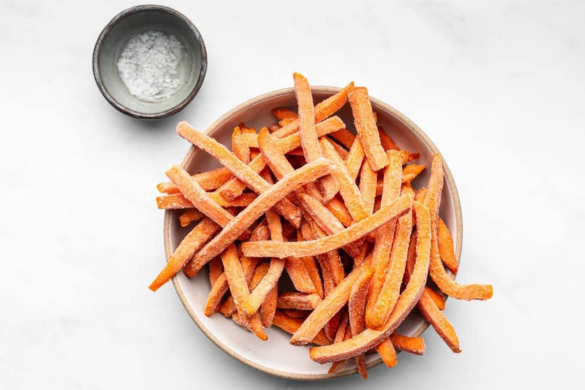 Tiefkühl-Süßkartoffel-Pommes aus der Heißluftfritteuse 3 Frisch zubereitete Süßkartoffelpommes aus der Heißluftfritteuse, perfekt goldbraun und knusprig, bereit zum Servieren und Genießen.