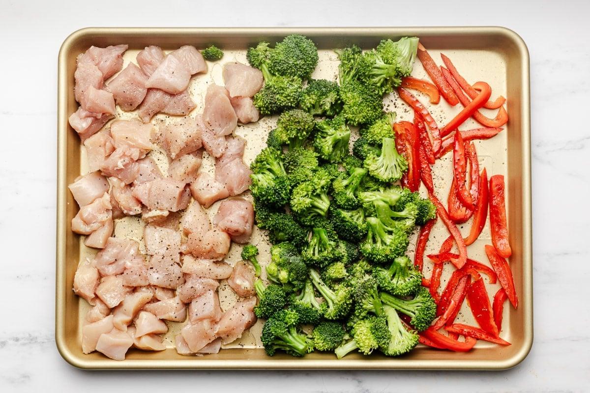 Einfaches Cashew-Hähnchen vom Blech 3 Nahaufnahme von perfekt gebratenem Hähnchen, Brokkoli und Paprika mit Cashewkernen auf einem Backblech