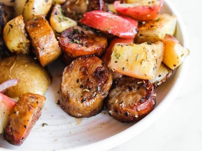 Wurst mit Äpfeln und Kartoffeln vom Blech 3 Nahaufnahme der geschnittenen Wurst, Kartoffeln und Äpfel auf einem Backblech, bereit zum Würzen
