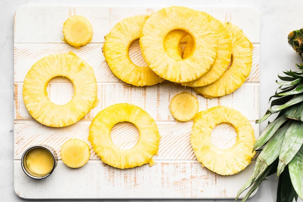 Eine halb geschnittene, frische Ananas auf einem Schneidebrett, bereit zum Schneiden von Ringen.