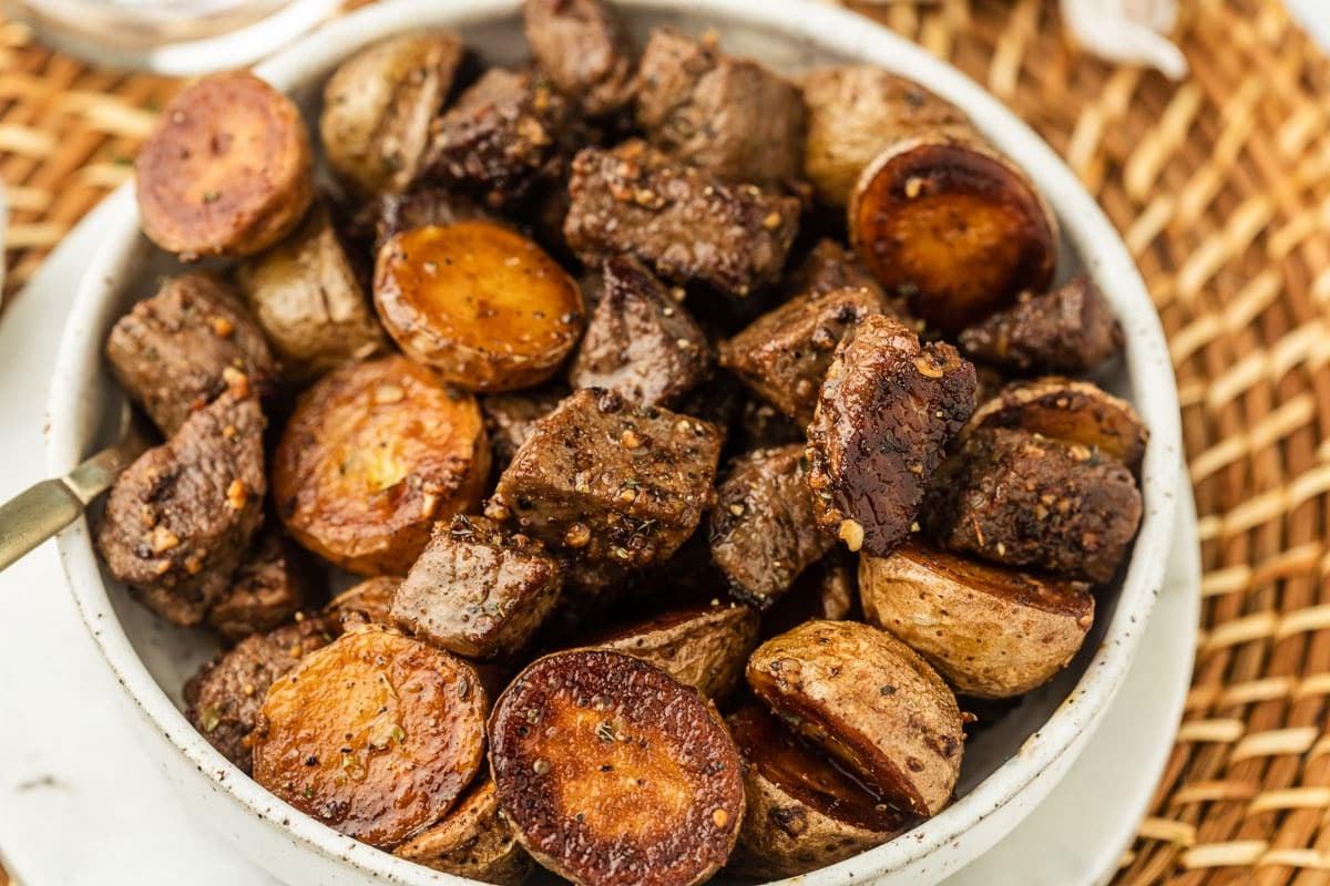 Knoblauch-Steak und Kartoffeln 4 Fertiges Knoblauch-Steak und Kartoffelpfanne, reichlich mit frischen Kräutern garniert.