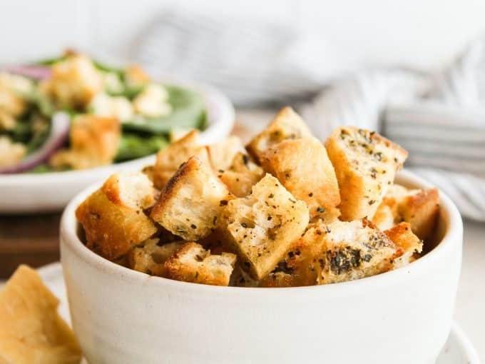 Hausgemachte Croutons 4 Brotwürfel werden in einem Ziplock-Beutel geschüttelt, um sie gleichmäßig mit Öl und Gewürzen zu überziehen.