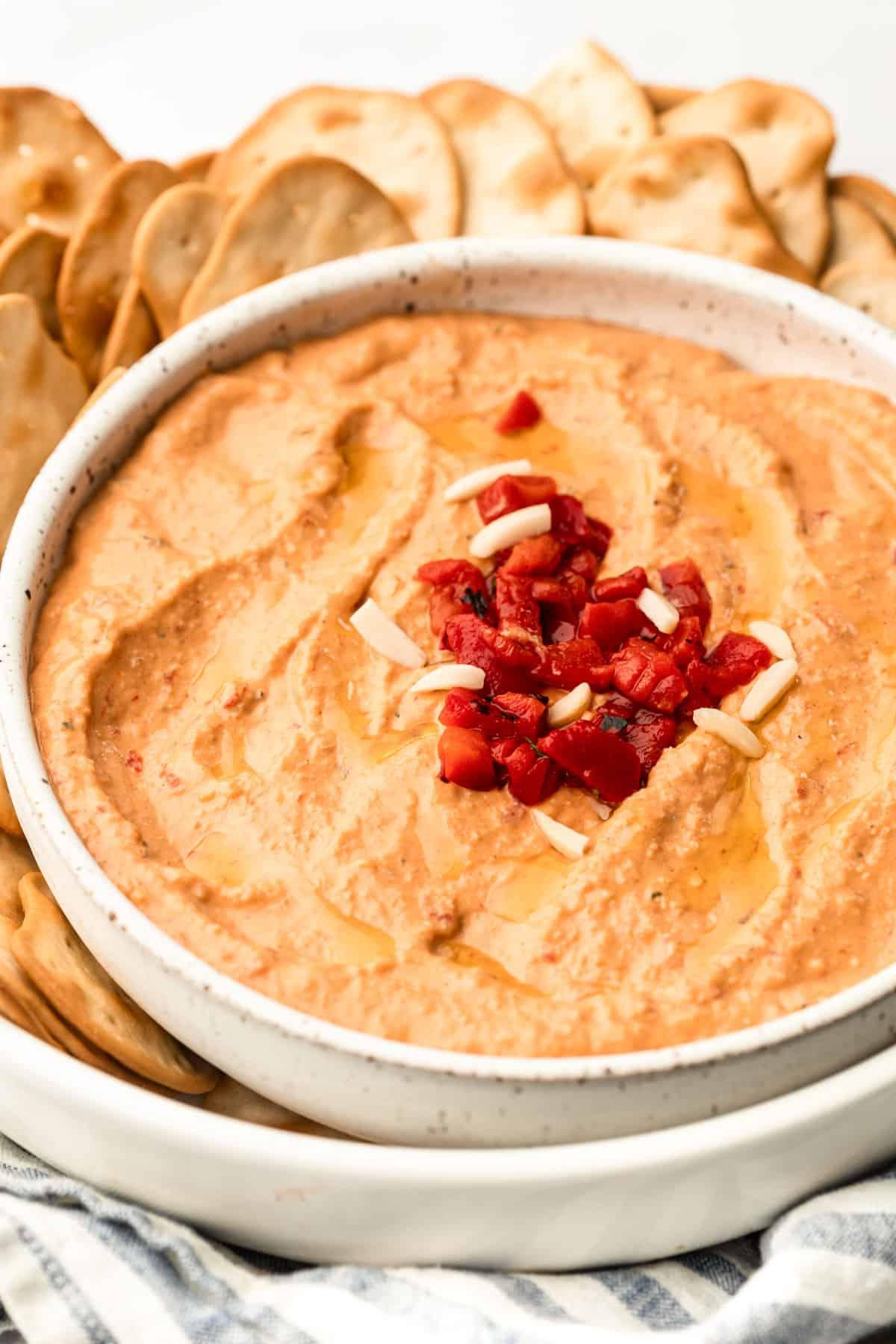 **Gerösteter Rote Paprika Hummus** 4 Nahaufnahme von cremigem Rote-Paprika-Hummus in einer Schale, bereit zum Servieren.