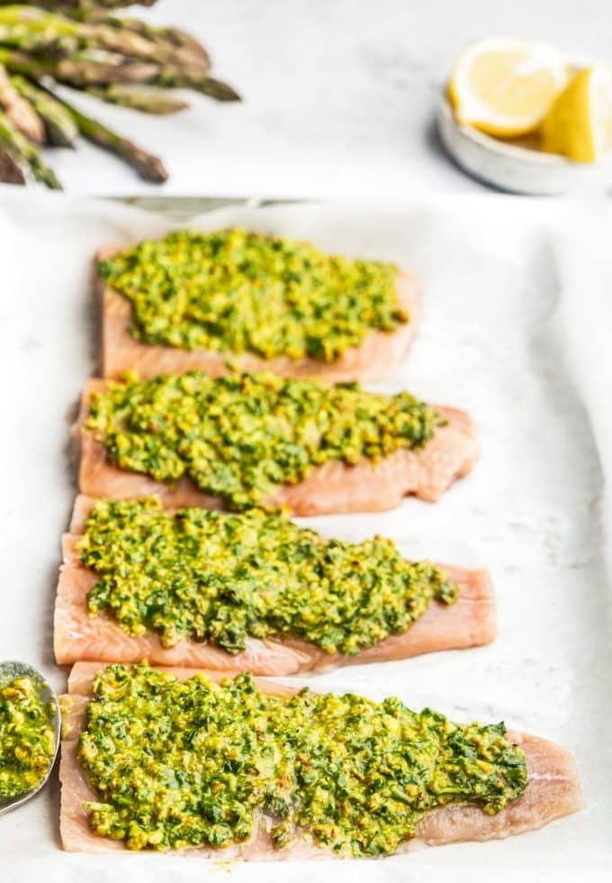 Lachs in Pistazien-Kräuter-Kruste mit Spargel 4 Frischer grüner Spargel auf einem Backblech, leicht beträufelt mit Olivenöl und gewürzt, bereit zum Backen