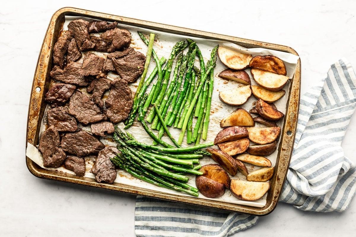Einfaches Steak-Blechgericht 4 Blechgericht mit Steak, Kartoffelspalten und Spargel im Ofen