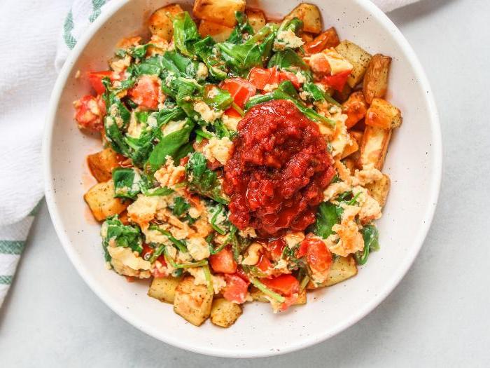 Rührei mit Heißluftfrittier-Kartoffeln 4 Nahaufnahme eines Rühreis mit Spinat und Tomaten, reichhaltig und farbenfroh.