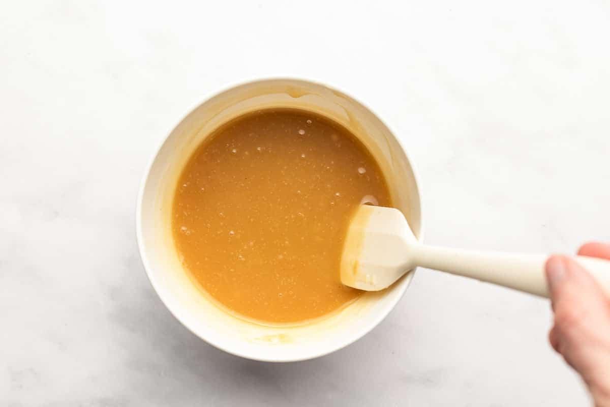 Nahaufnahme der glatten, cremigen Textur der Honig-Senf-Sauce in einer weißen Schale.