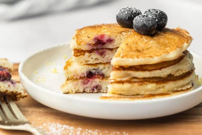 Pfannkuchen mit Sirup, Blaubeeren und Zitronenschale angerichtet