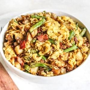Wochenendfrühstückspfanne 5 Nahaufnahme des fertig zubereiteten Wochenend-Rühreis in einer Pfanne, garniert mit frischen Kräutern.