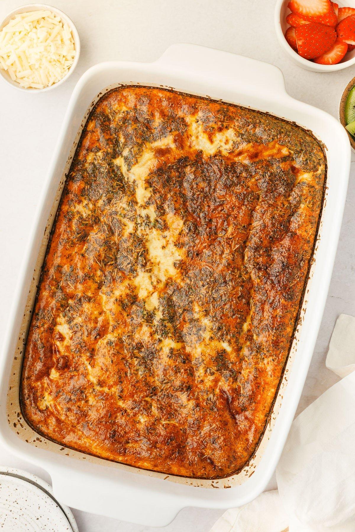 Low Carb Wurst-Cheddar Frühstücksauflauf 5 Portion Low-Carb Wurst-Cheddar-Frühstücksauflauf auf einem Teller, mit frischen Beilagen
