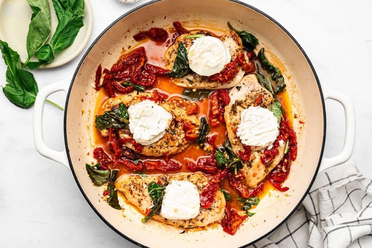 Sonnengetrocknete Tomaten-Ziegenkäse-Hähnchen (nach Art von Chicken Bryan) 5 Hähnchen mit Ziegenkäse und sonnengetrockneten Tomaten, bereit zum Servieren auf einem Teller.