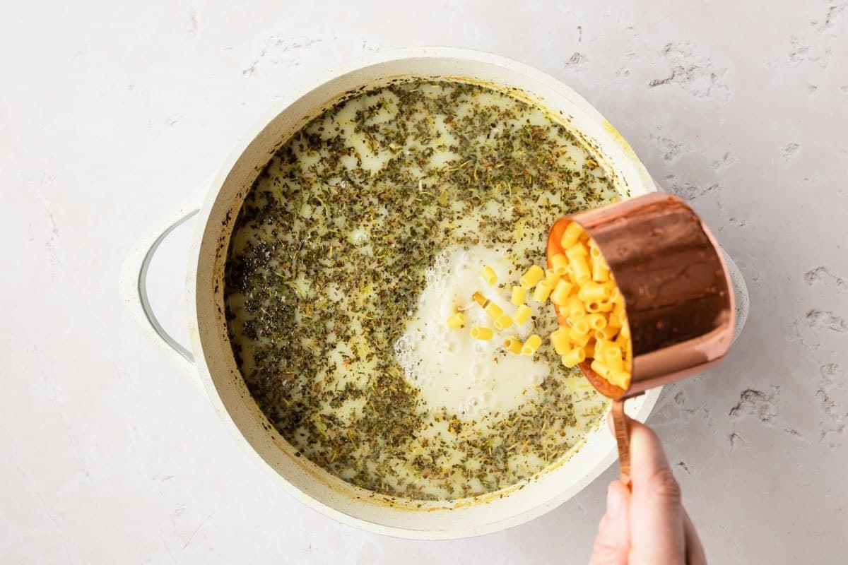 Cremige Hähnchennudelsuppe 5 Eine Schale cremiger Hühnernudelsuppe, perfekt für kalte Tage, mit frischen Kräutern garniert