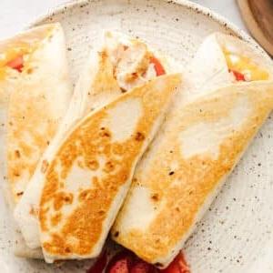 Gegrillte Ranch-Hähnchen-Wraps 5 Nahaufnahme eines einzelnen Hähnchen-Ranch-Wraps, dessen goldbraune Außenseite und appetitliche Füllung zu sehen sind.
