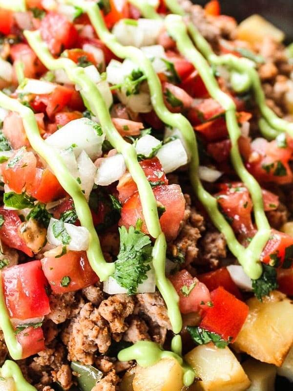 Leserlieblinge: Gesunde Hauptgerichte 5 Eine farbenfrohe Truthahn-Taco-Pfanne mit Kartoffeln, Paprika, Zwiebeln, gewürztem Truthhackfleisch und Avocado-Dressing