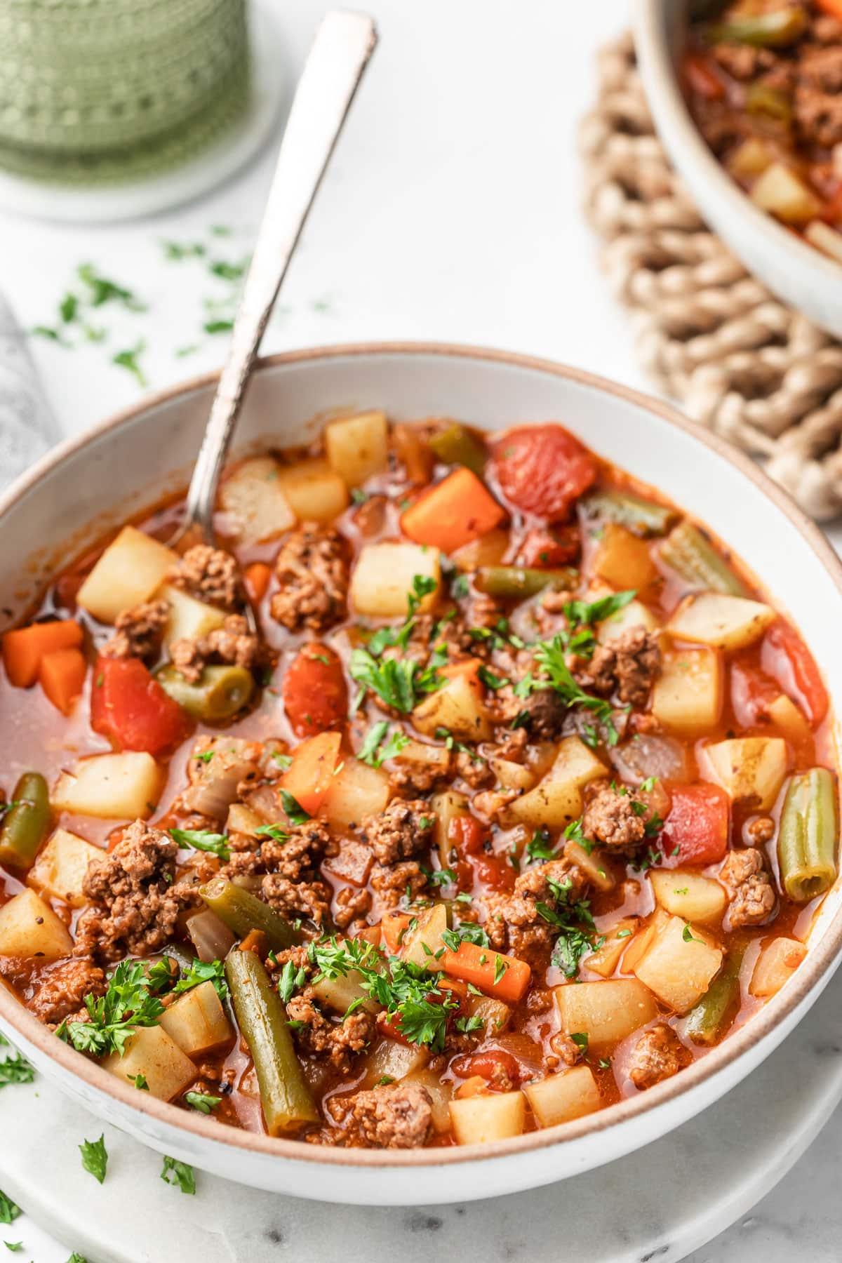 Gesunde 30-Minuten-Hamburger-Suppe 5 Eine volle Schüssel Hackfleischsuppe, mit Fokus auf die Textur der Suppe mit Hackfleisch und Gemüse.