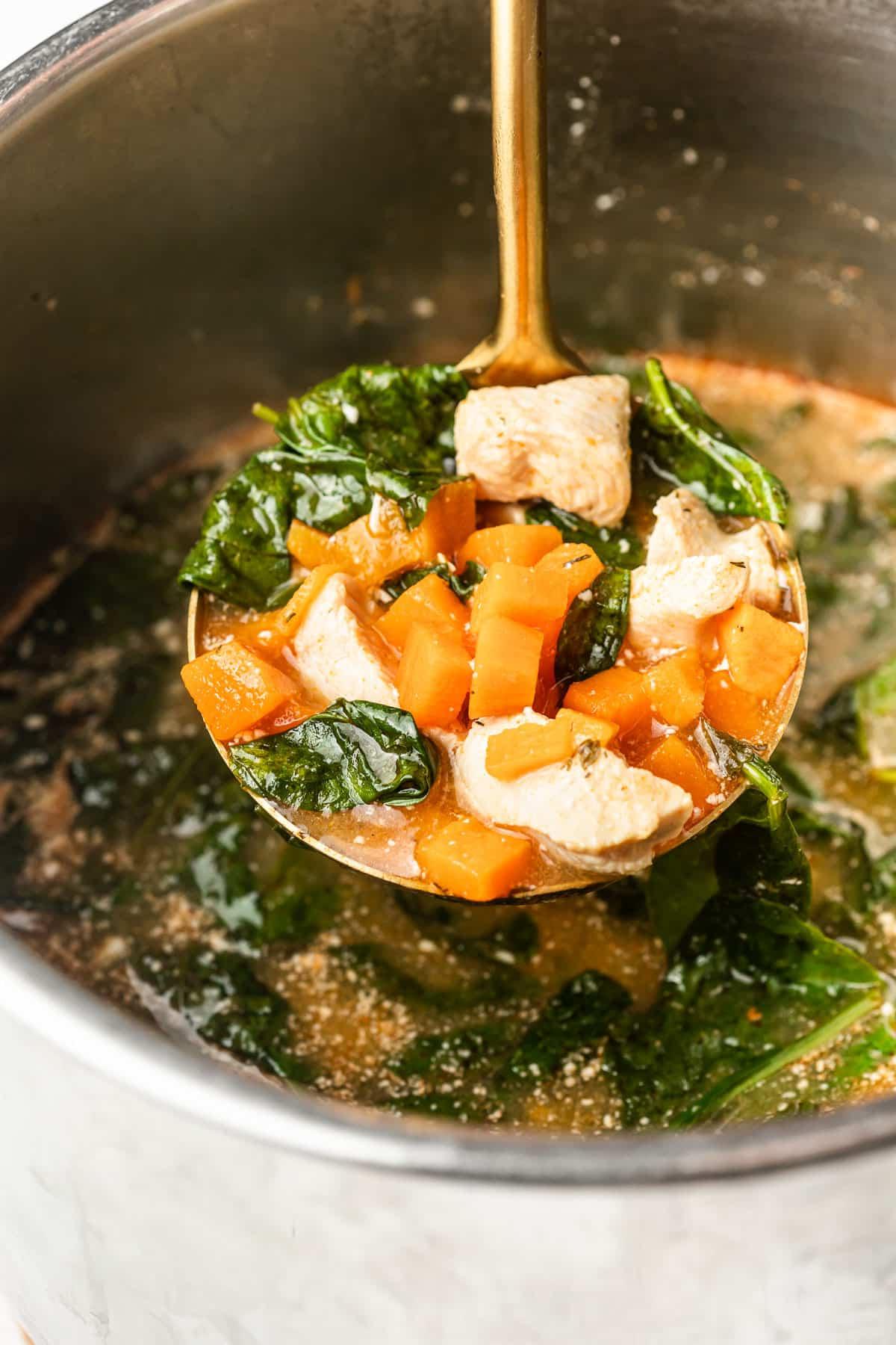 Ansicht von oben auf die Instant Pot Buffalo Hähnchen Süßkartoffel Suppe in einer großen Schüssel mit Beilagen.