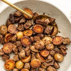 Knoblauch-Steak und Kartoffeln 6 Nahaufnahme einer perfekt gebratenen Knoblauch-Steak-Pfanne mit Kartoffeln, servierfertig in einer Pfanne.