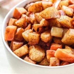 Ahorngesüßte angebratene Äpfel 6 Nahaufnahme von gebratenen Äpfeln in einer Schüssel mit einem Hauch von Ahornsirup und Zimt