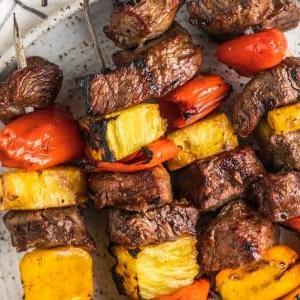 Hawaii-Steak-Spieße 6 Hawaiianische Steak-Spieße auf einem Grillrost mit leichter Rauchentwicklung