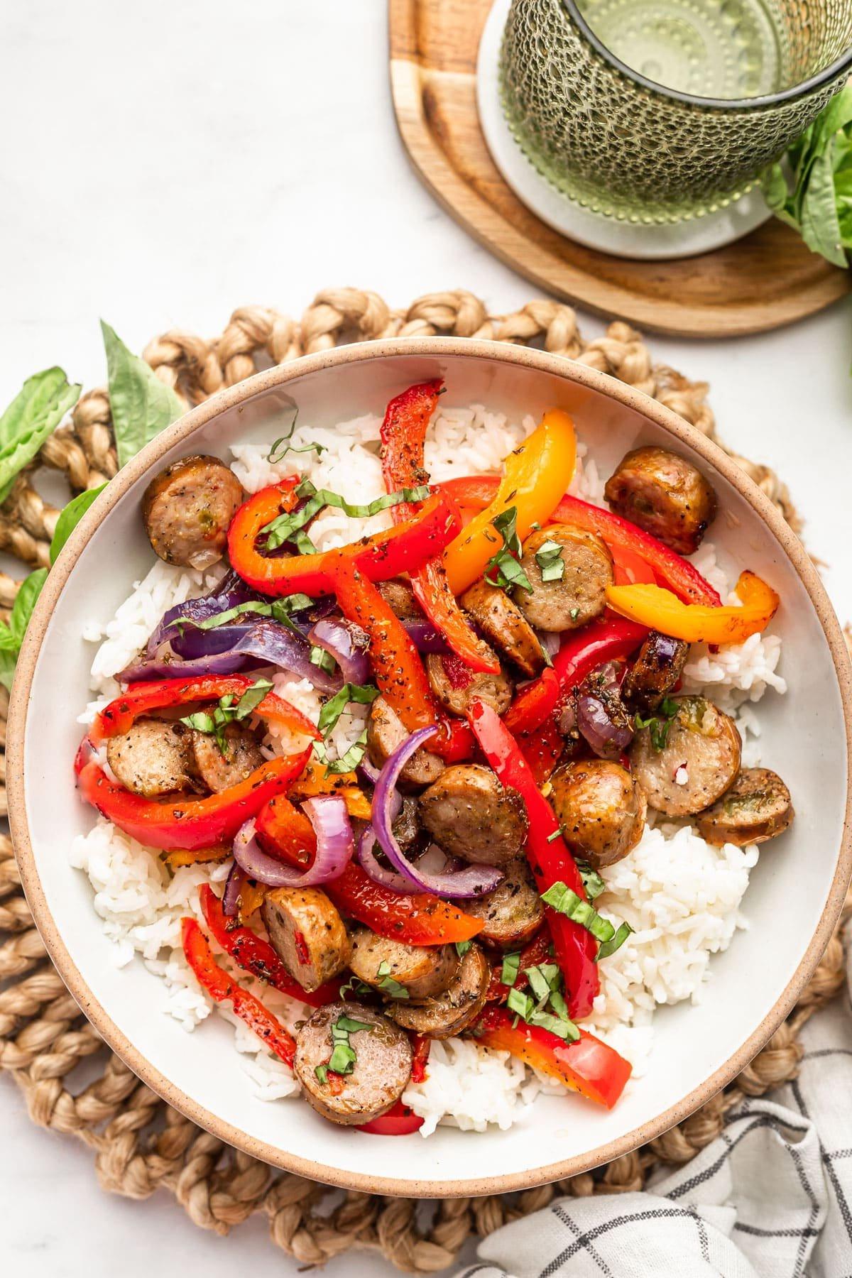 **Einfaches Backblechgericht mit Italienischer Wurst und Paprika** 6 Eine Nahaufnahme des fertig zubereiteten Gerichts, die die goldenen Farben der Wurst und des Gemüses hervorhebt.