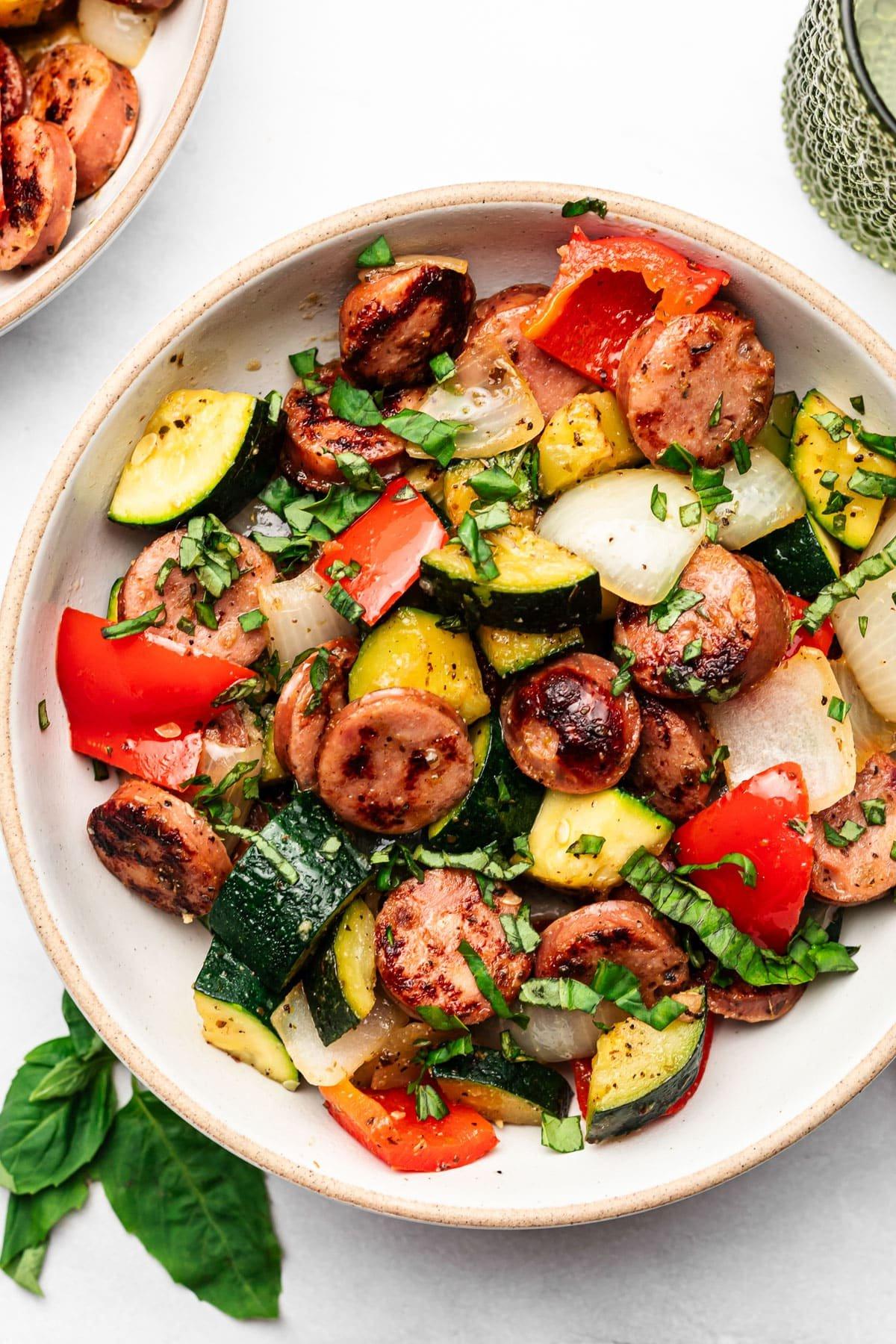 **20-Minuten-Wurst-Zucchini-Pfanne** 6 Eine Nahaufnahme des Pfannengerichts in einer gusseisernen Pfanne, bereit zum Servieren.