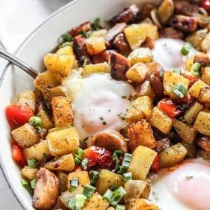 Hähnchenwurst-Paprika-Pfanne 5 Ein Teil des fertigen Hähnchenwurst- & Paprika-Hash in einer Pfanne, mit Eiern und frischen Kräutern