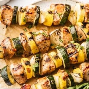 Gegrillte Knoblauch-Balsamico-Hähnchenspieße mit Gemüse und Grillspuren.