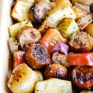 Wurst mit Äpfeln und Kartoffeln vom Blech 7 Ein nahaufnahme Bild des fertigen Blechgerichts, das auf einem Backblech angerichtet ist.