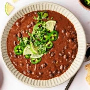 Einfache 20-Minuten-Schwarzbohnensuppe 7 Ein Teller mit einer Portion schwarzer Bohnensuppe mit Koriander.