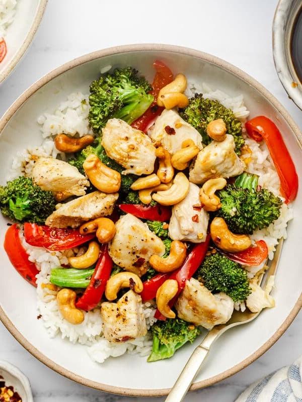 Leserlieblinge: Gesunde Hauptgerichte 10 Hähnchen, Cashewkerne, Brokkoli und rote Paprika auf einem Backblech, übergossen mit einer würzigen Soße
