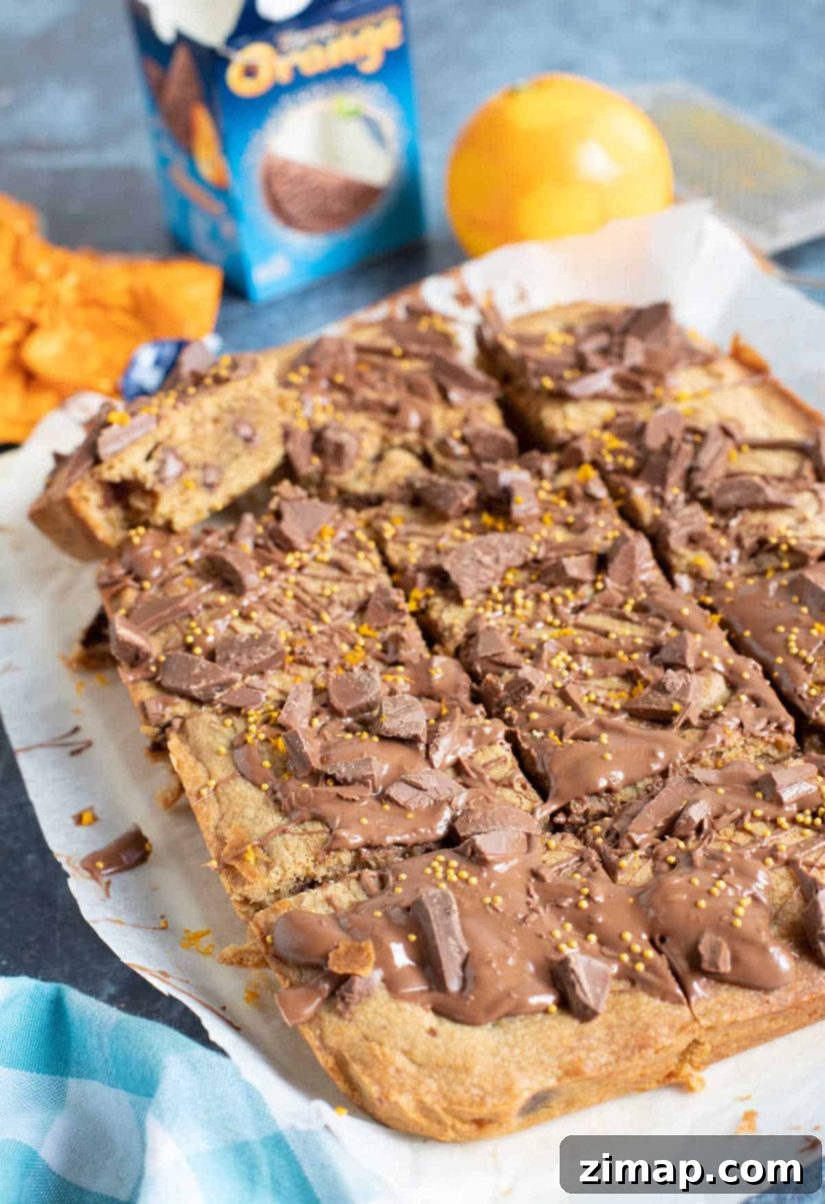 Πανεύκολες Μπάρες Σοκολάτα Πορτοκάλι 2 Chocolate orange cookie bars cut into squares on a board.